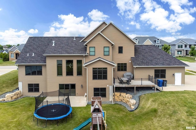 5541 Pigeon Creek Rd, Bettendorf, IA 52722 - back of house with a trampoline, a yard, and roof with shingles