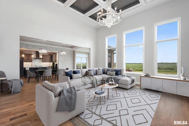 5541 Pigeon Creek Rd, Bettendorf, IA 52722 - living room with a chandelier, a high ceiling, wood finished floors, coffered ceiling, and beam ceiling