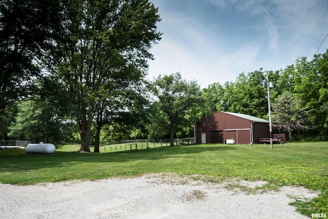 3770 153rd St, Blue Grass, IA 52726 - view of yard with an outbuilding, a detached garage, an outdoor structure, and view of wooded area