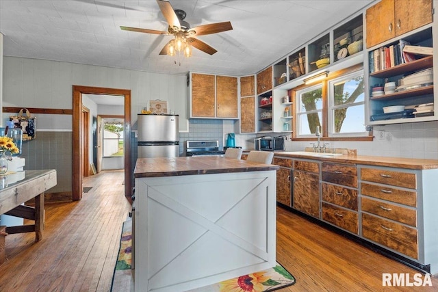 3292 110th St, Stockton, IA 52769 - kitchen featuring open shelves, wood-type flooring, butcher block counters, and brown cabinets