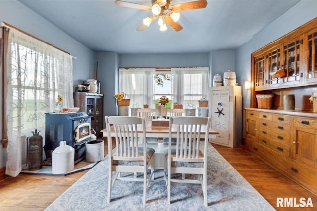 3292 110th St, Stockton, IA 52769 - dining room with a wood stove, ceiling fan, and wood finished floors