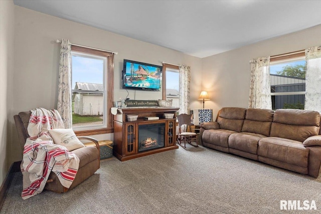 3292 110th St, Stockton, IA 52769 - carpeted living area featuring a glass covered fireplace and plenty of natural light