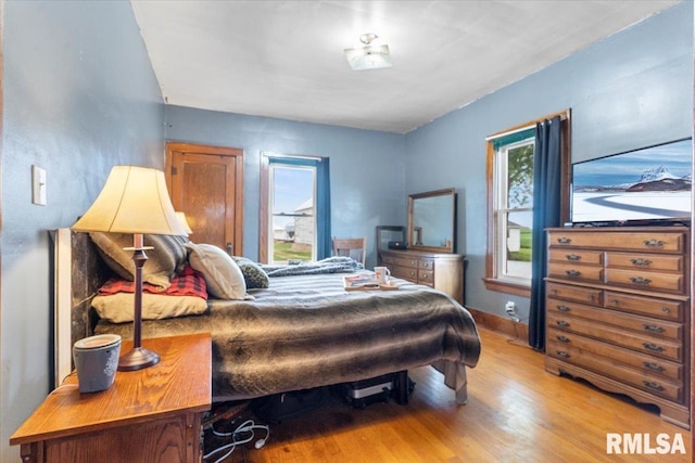 3292 110th St, Stockton, IA 52769 - bedroom with multiple windows and wood finished floors