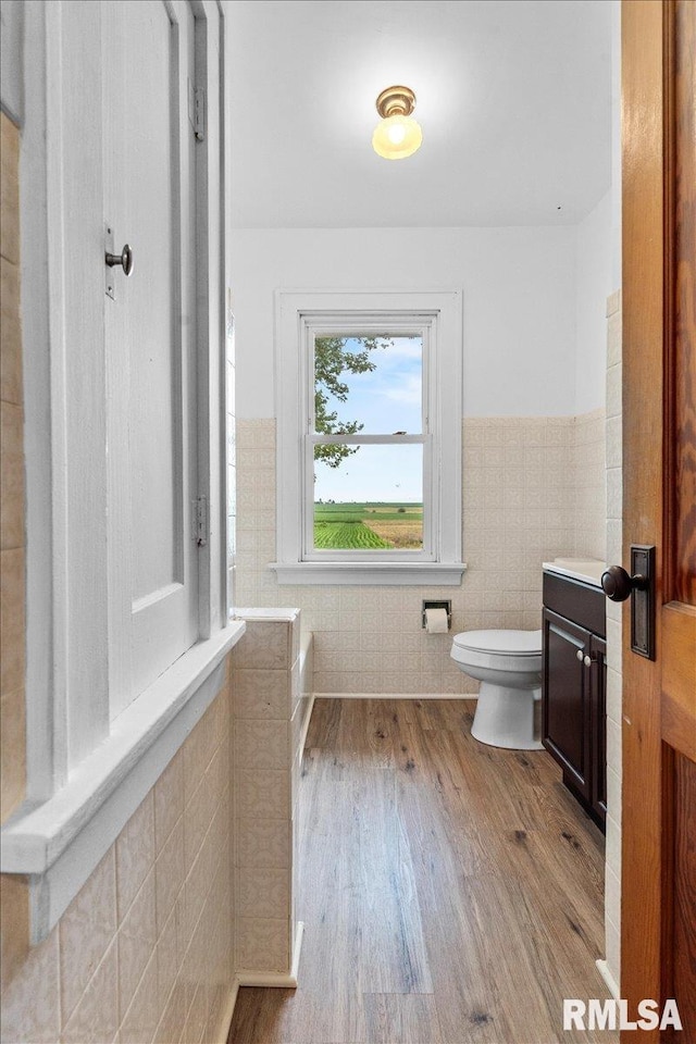 3292 110th St, Stockton, IA 52769 - bathroom with vanity, tile walls, wainscoting, and wood finished floors