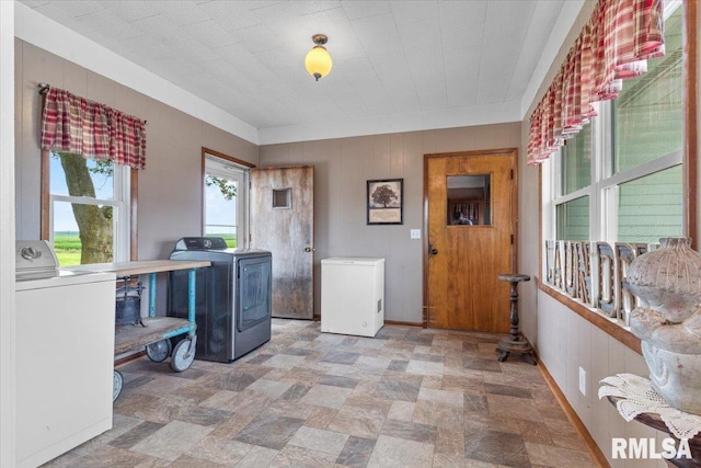 3292 110th St, Stockton, IA 52769 - washroom with washer and clothes dryer, wood walls, and stone finish floors