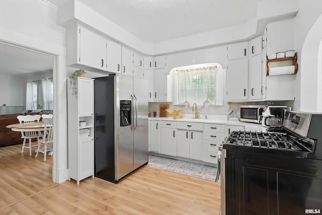 3123 Commodore St, Davenport, IA 52802 - kitchen featuring appliances with stainless steel finishes, light wood-style floors, open shelves, and white cabinets