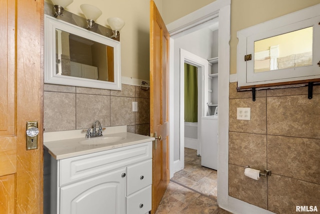 117 W 14th St, Davenport, IA 52803 - bathroom featuring tile walls, vanity, washer / dryer, and wainscoting