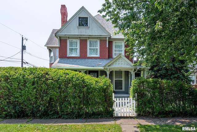 117 W 14th St, Davenport, IA 52803 - view of front of home with a fenced front yard, roof with shingles, covered porch, and a chimney