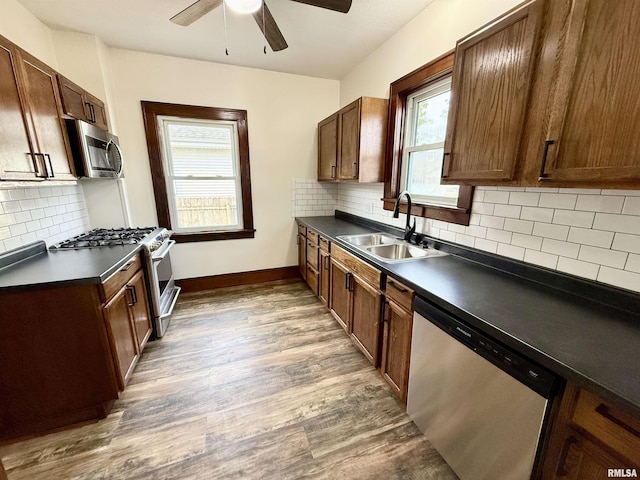 1820 13th St, Rock Island, IL 61201 - kitchen featuring stainless steel appliances, dark countertops, ceiling fan, wood finished floors, and tasteful backsplash