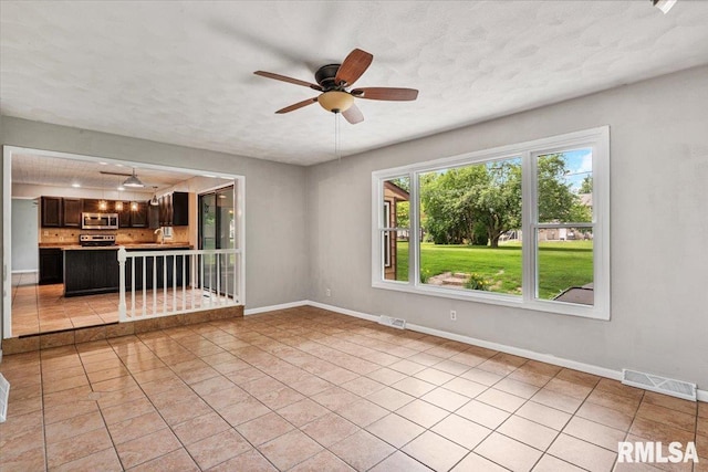 3611 75th St, Moline, IL 61265 - unfurnished living room with ceiling fan and light tile patterned floors