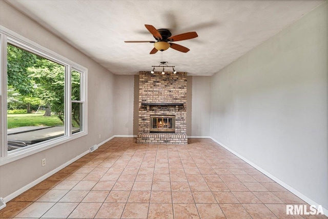 3611 75th St, Moline, IL 61265 - unfurnished living room with ceiling fan, a fireplace, and light tile patterned flooring