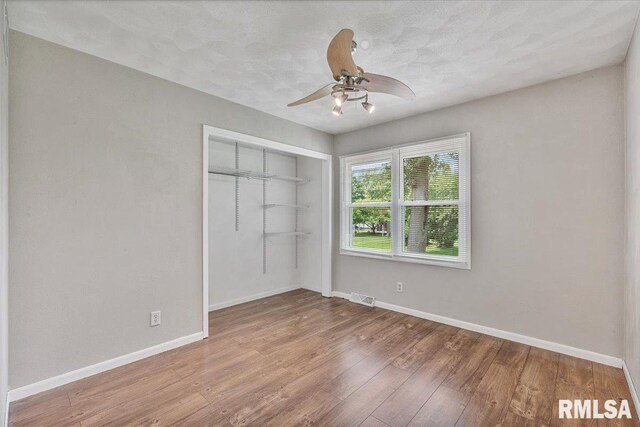 3611 75th St, Moline, IL 61265 - unfurnished bedroom with wood finished floors, a closet, and ceiling fan