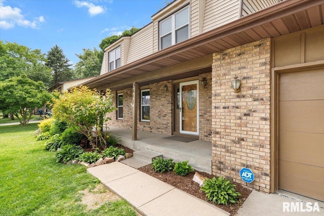 3611 75th St, Moline, IL 61265 - view of exterior entry featuring a porch, brick siding, and a lawn