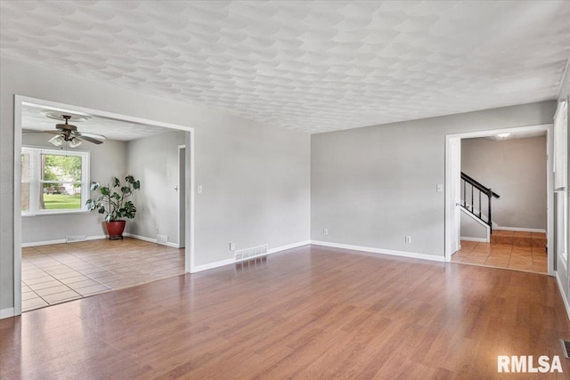 3611 75th St, Moline, IL 61265 - spare room with stairway, wood finished floors, and a ceiling fan