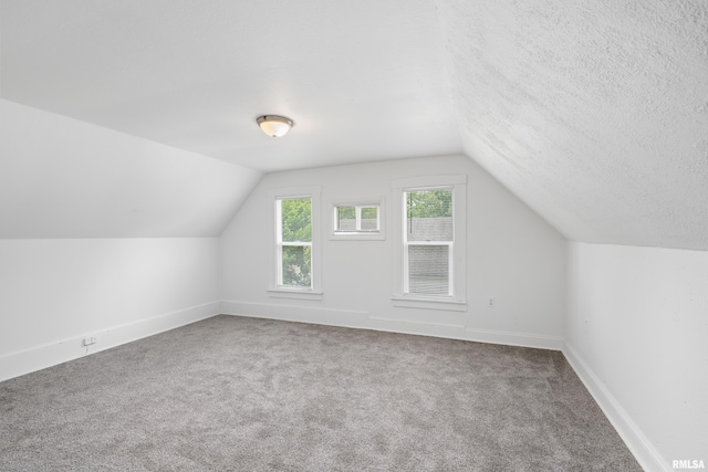 320 16th Ave N, Clinton, IA 52732 - bonus room featuring lofted ceiling, carpet flooring, and a textured ceiling