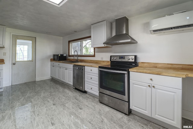 828 10th Ave, Fulton, IL 61252 - kitchen with appliances with stainless steel finishes, wall chimney range hood, a wall mounted air conditioner, wood counters, and white cabinetry