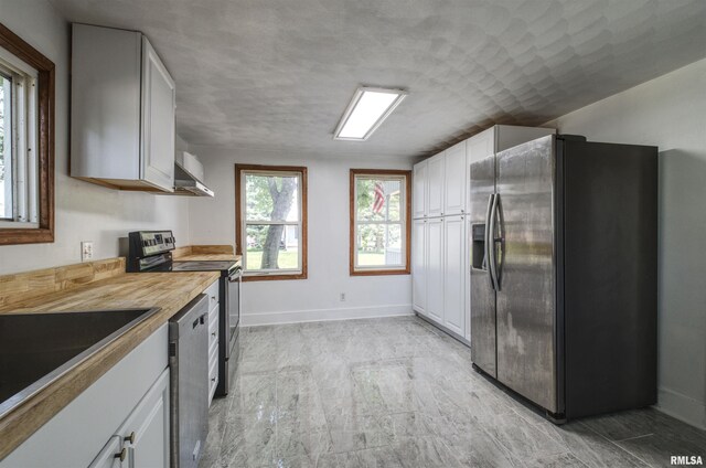 828 10th Ave, Fulton, IL 61252 - kitchen featuring appliances with stainless steel finishes, white cabinets, wall chimney range hood, and light countertops