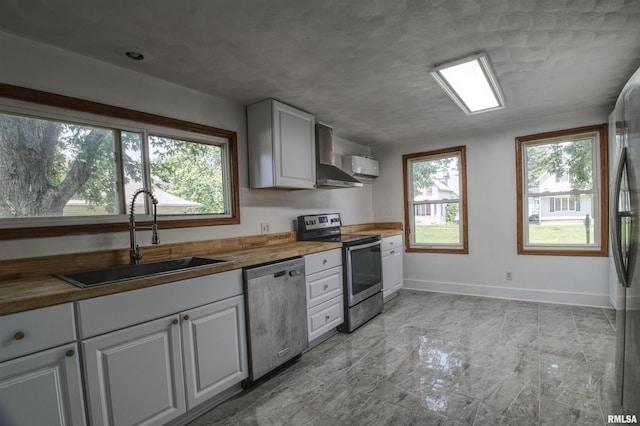 828 10th Ave, Fulton, IL 61252 - kitchen with appliances with stainless steel finishes, wooden counters, healthy amount of natural light, and white cabinets