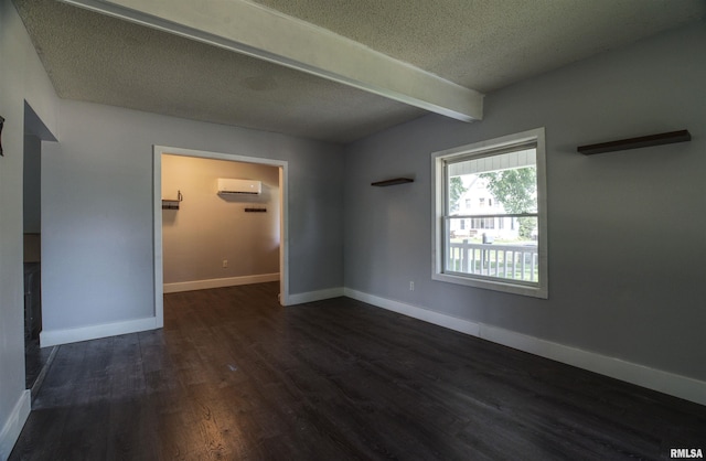 828 10th Ave, Fulton, IL 61252 - empty room with a wall unit AC, beam ceiling, dark wood-style flooring, and a textured ceiling