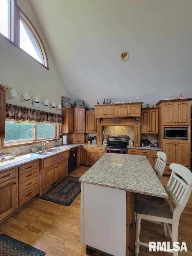 313 Double C Farm Ln, Dongola, IL 62964 - kitchen featuring stainless steel appliances, high vaulted ceiling, a kitchen island, a breakfast bar, and light wood-type flooring