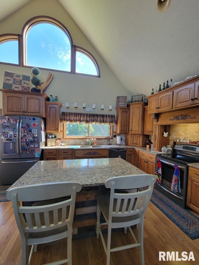 313 Double C Farm Ln, Dongola, IL 62964 - kitchen with range with electric stovetop, stainless steel refrigerator with ice dispenser, a kitchen island, light stone counters, and a kitchen bar