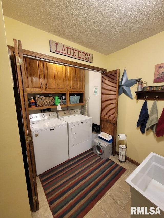 313 Double C Farm Ln, Dongola, IL 62964 - washroom featuring cabinet space, separate washer and dryer, a textured ceiling, and light tile patterned floors