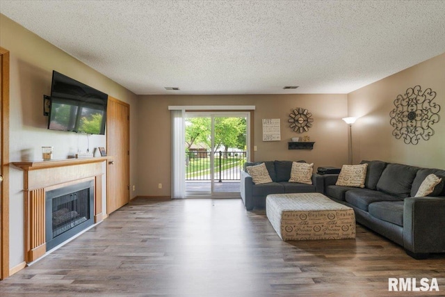 4725 Kynnelworth Dr Unit 8, Bettendorf, IA 52722 - living area with wood finished floors, a textured ceiling, and a fireplace