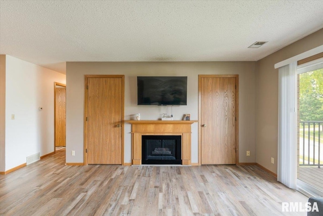 4725 Kynnelworth Dr Unit 8, Bettendorf, IA 52722 - unfurnished living room featuring wood finished floors, a textured ceiling, and a fireplace