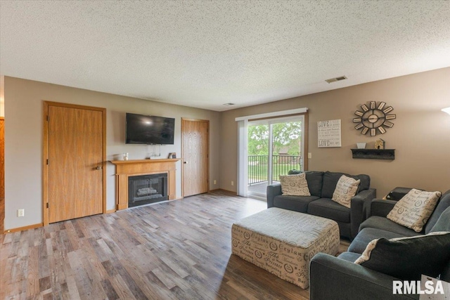 4725 Kynnelworth Dr Unit 8, Bettendorf, IA 52722 - living room with wood finished floors, a textured ceiling, and a fireplace