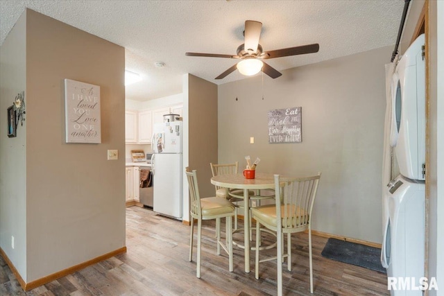 4725 Kynnelworth Dr Unit 8, Bettendorf, IA 52722 - dining room featuring estacked washer and dryer, light wood finished floors, a ceiling fan, and a textured ceiling