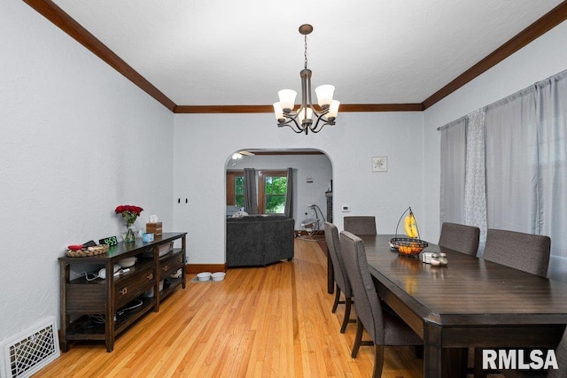 2531 5th St, Moline, IL 61265 - dining room featuring arched walkways, a chandelier, ornamental molding, and light wood-style floors
