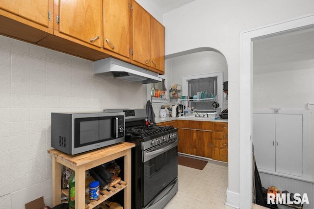 2531 5th St, Moline, IL 61265 - kitchen with appliances with stainless steel finishes, under cabinet range hood, brown cabinets, and light countertops