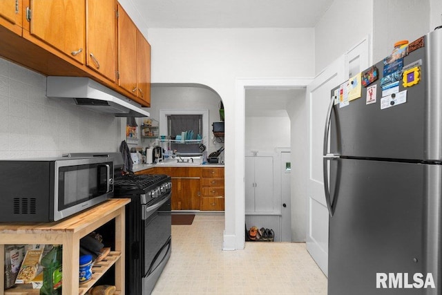 2531 5th St, Moline, IL 61265 - kitchen with appliances with stainless steel finishes, ventilation hood, brown cabinetry, light countertops, and tasteful backsplash