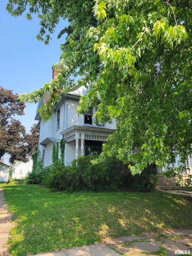 606 Meridian St Unit 1 & 2, Tipton, IA 52772 - view of side of property featuring a chimney and a lawn