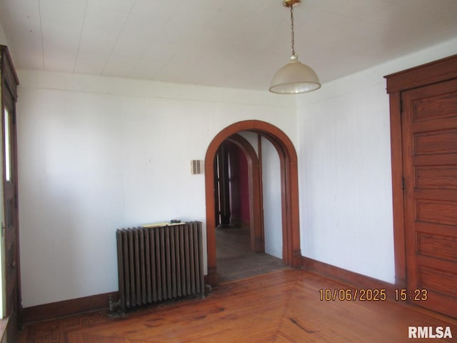 606 Meridian St Unit 1 & 2, Tipton, IA 52772 - unfurnished room with radiator and arched walkways
