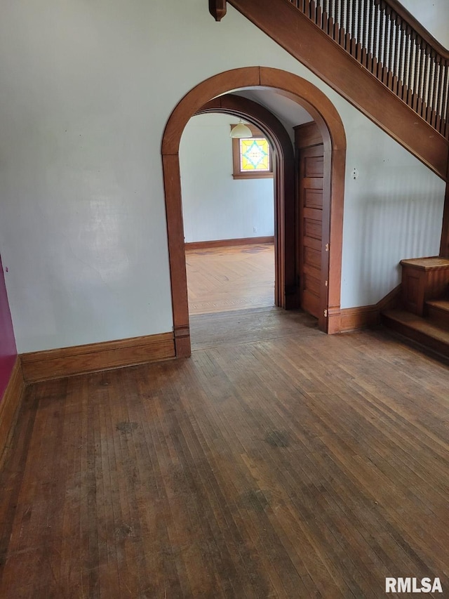 606 Meridian St Unit 1 & 2, Tipton, IA 52772 - unfurnished living room featuring wood-type flooring and arched walkways