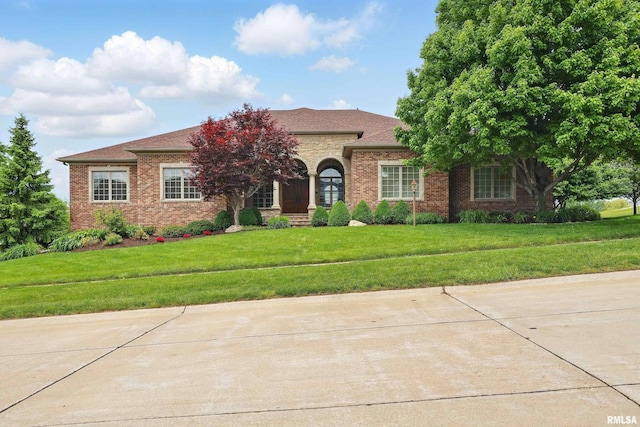 11 Sandstone Ct, Le Claire, IA 52753 - view of front of house with brick siding, a front yard, and roof with shingles