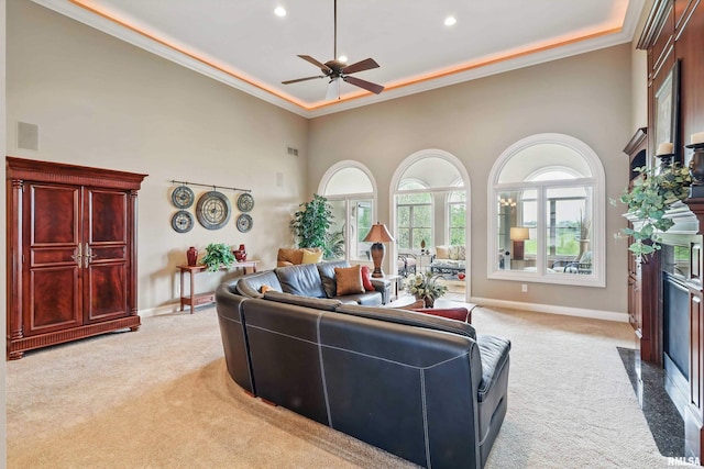 11 Sandstone Ct, Le Claire, IA 52753 - living room featuring light carpet, a high ceiling, ornamental molding, a ceiling fan, and a premium fireplace