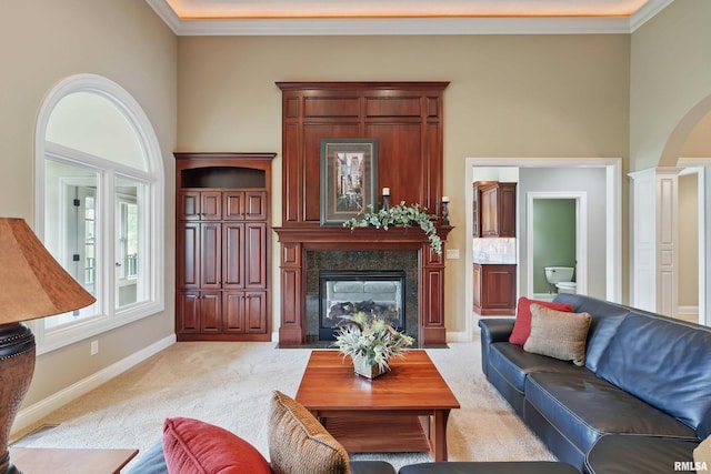 11 Sandstone Ct, Le Claire, IA 52753 - living room with light colored carpet, a premium fireplace, ornamental molding, arched walkways, and ornate columns