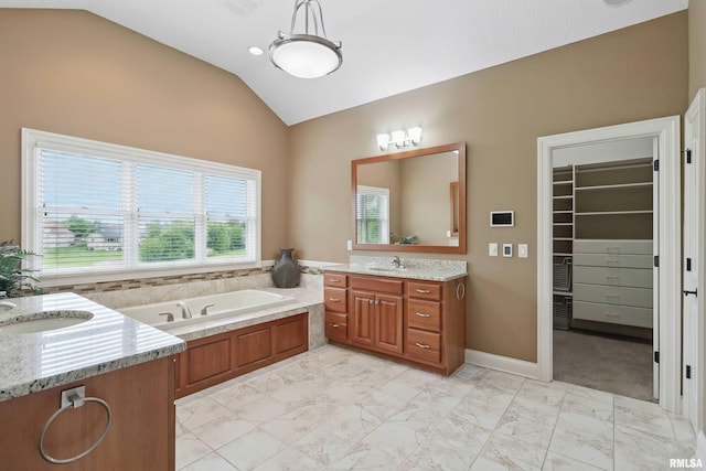 11 Sandstone Ct, Le Claire, IA 52753 - bathroom featuring lofted ceiling, two vanities, marble look tile flooring, a bath, and a walk in closet