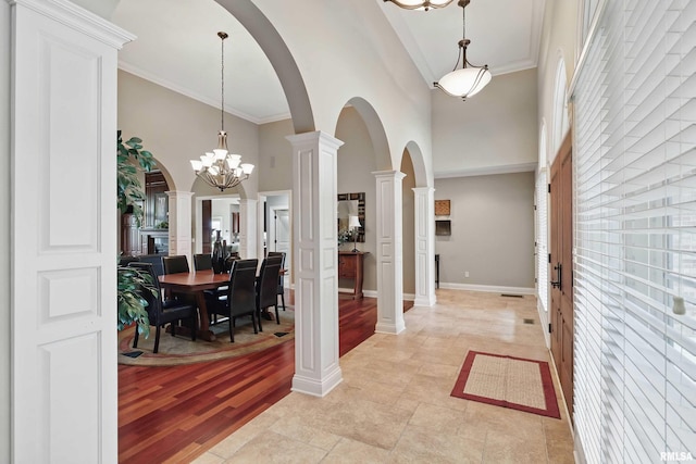 11 Sandstone Ct, Le Claire, IA 52753 - entryway with a towering ceiling, ornate columns, arched walkways, a chandelier, and crown molding