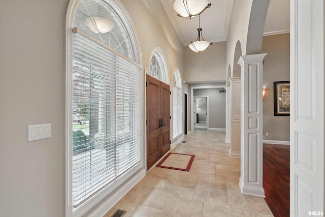 11 Sandstone Ct, Le Claire, IA 52753 - foyer with arched walkways, ornamental molding, stone tile flooring, a towering ceiling, and decorative columns