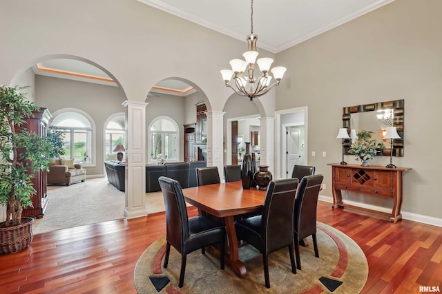 11 Sandstone Ct, Le Claire, IA 52753 - dining area with ornate columns, arched walkways, wood finished floors, ornamental molding, and a chandelier