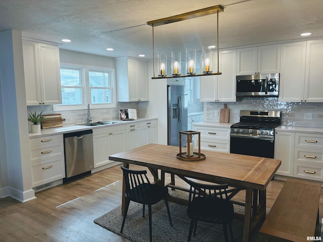323 N Vail St, Geneseo, IL 61254 - kitchen featuring stainless steel appliances, backsplash, light countertops, light wood finished floors, and recessed lighting