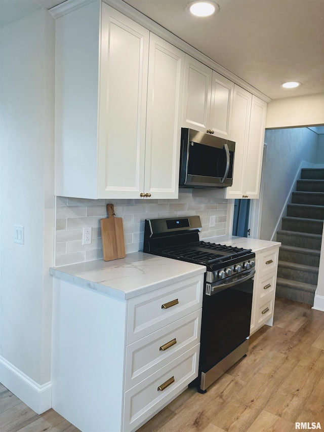 323 N Vail St, Geneseo, IL 61254 - kitchen with stainless steel appliances, white cabinets, light wood-style floors, decorative backsplash, and recessed lighting