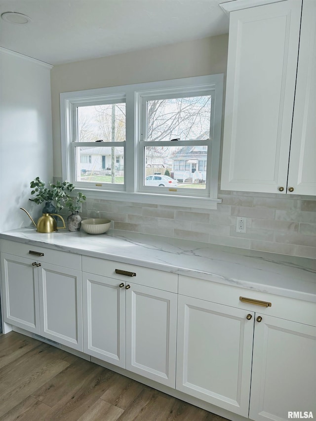 323 N Vail St, Geneseo, IL 61254 - kitchen featuring tasteful backsplash, light wood-style floors, light stone counters, and white cabinetry
