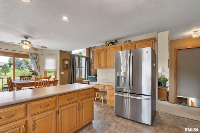1010 Meadows Cir, Bettendorf, IA 52722 - kitchen with stainless steel fridge, a textured ceiling, ceiling fan, light countertops, and recessed lighting