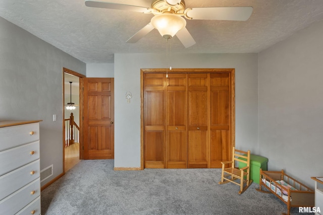 1010 Meadows Cir, Bettendorf, IA 52722 - unfurnished bedroom featuring carpet floors, a closet, a textured ceiling, and ceiling fan