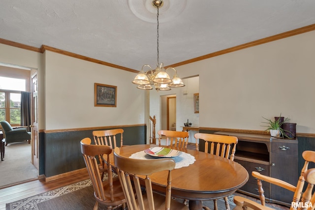 1010 Meadows Cir, Bettendorf, IA 52722 - dining area with wood finished floors, a chandelier, ornamental molding, and wainscoting