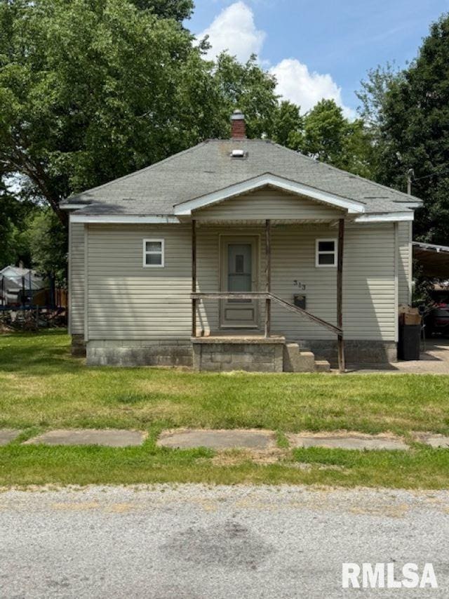 313 E 4th St, West Frankfort, IL 62896 - bungalow-style home with a chimney, a front yard, roof with shingles, and a carport